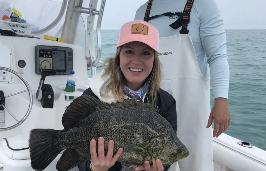 A woman holding a Triple Tail Fish in Madeira Beach, Florida.