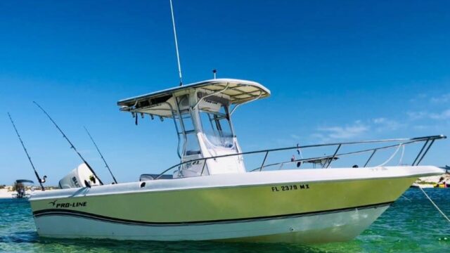 A small center console fishing boat anchored in the ocean.