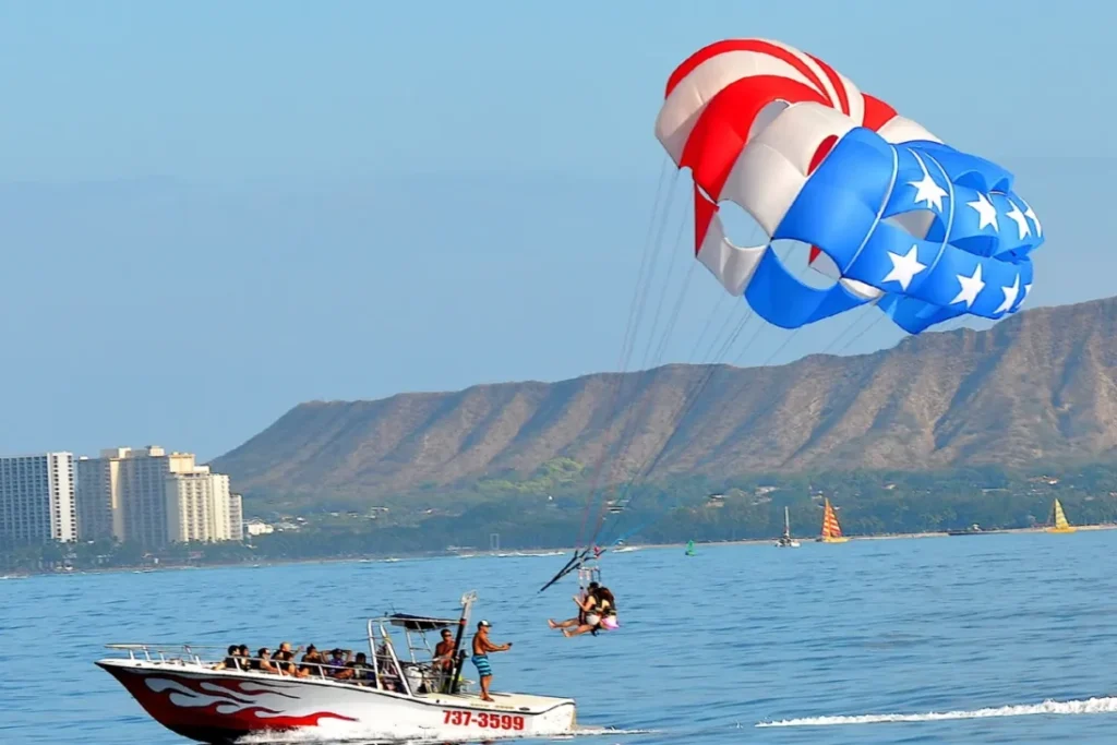 Parasailers landing back on the boat with Diamond Head Volcano in the background.