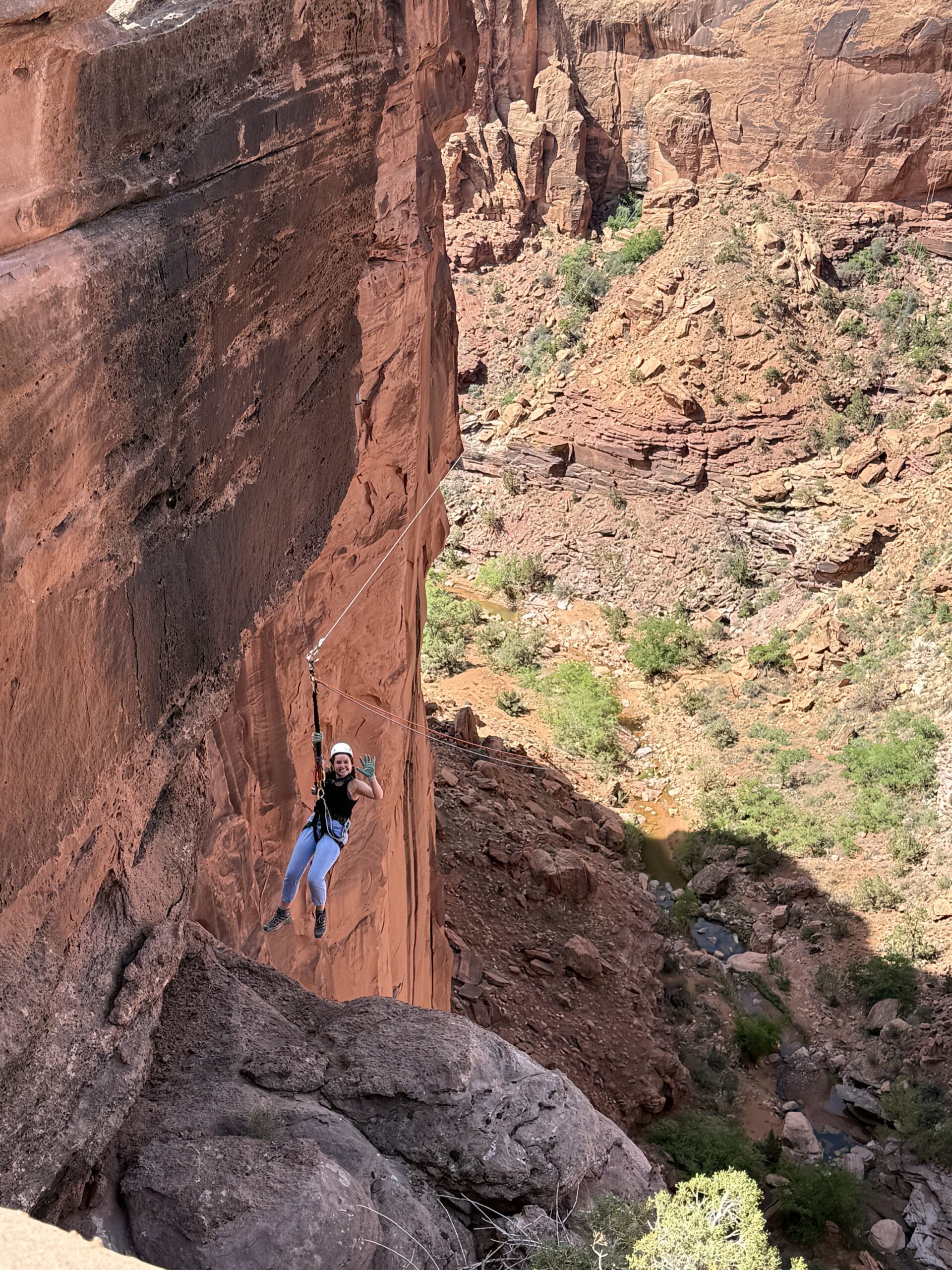 Girl swinging from a rope in Moab in a canyon.