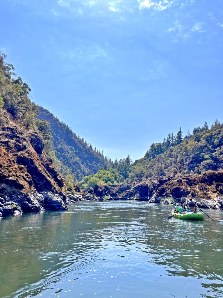 A raft rowing on a river away from the camera.