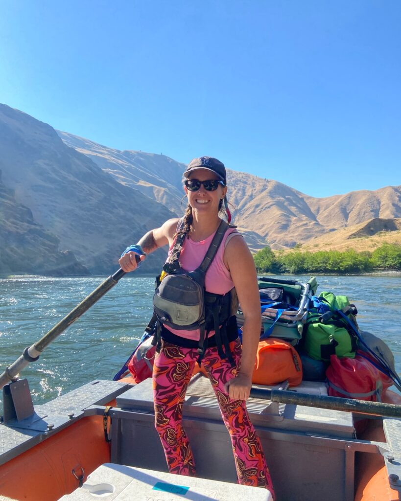 A women oarsman smiling on her raft.