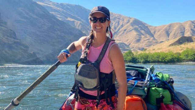 A women oarsman smiling on her raft.