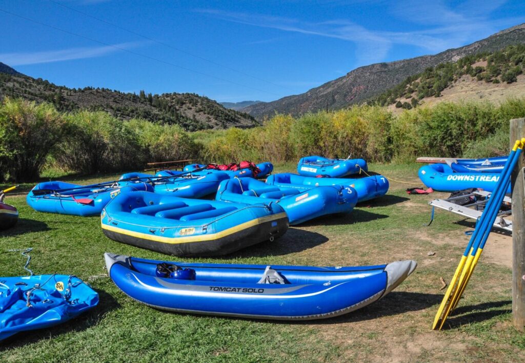 A fleet of blue rafts on a grass field.