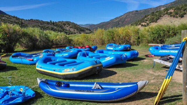 A fleet of blue rafts on a grass field.