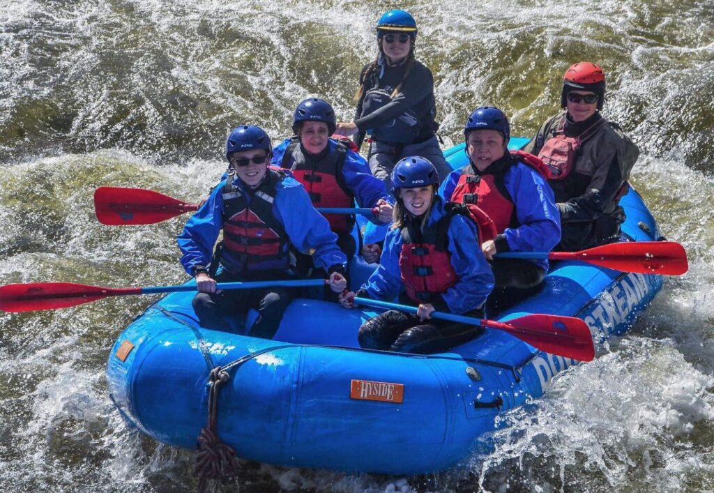 Whitewater rafters splashing into a rapid.