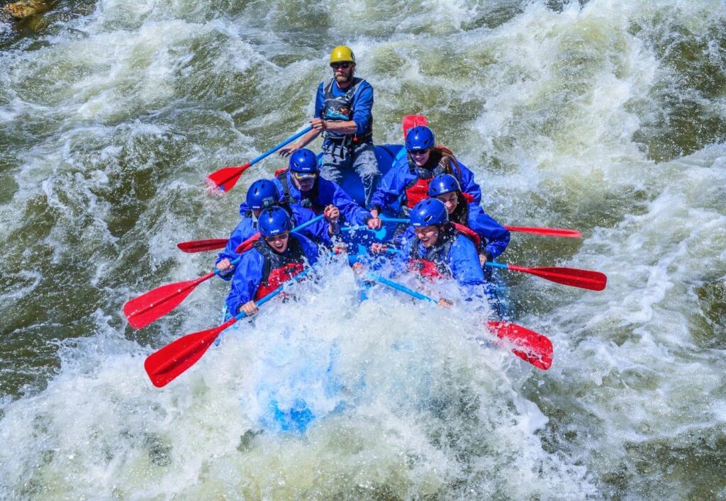 Whitewater rafters splashing into a rapid.