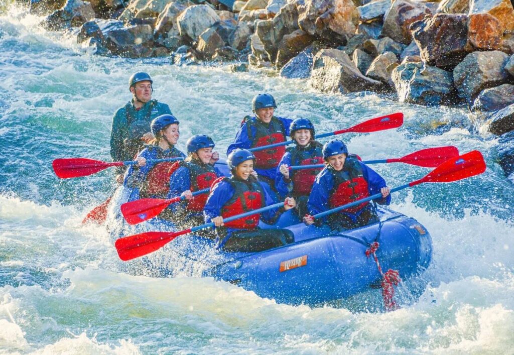Whitewater rafters splashing into a rapid.