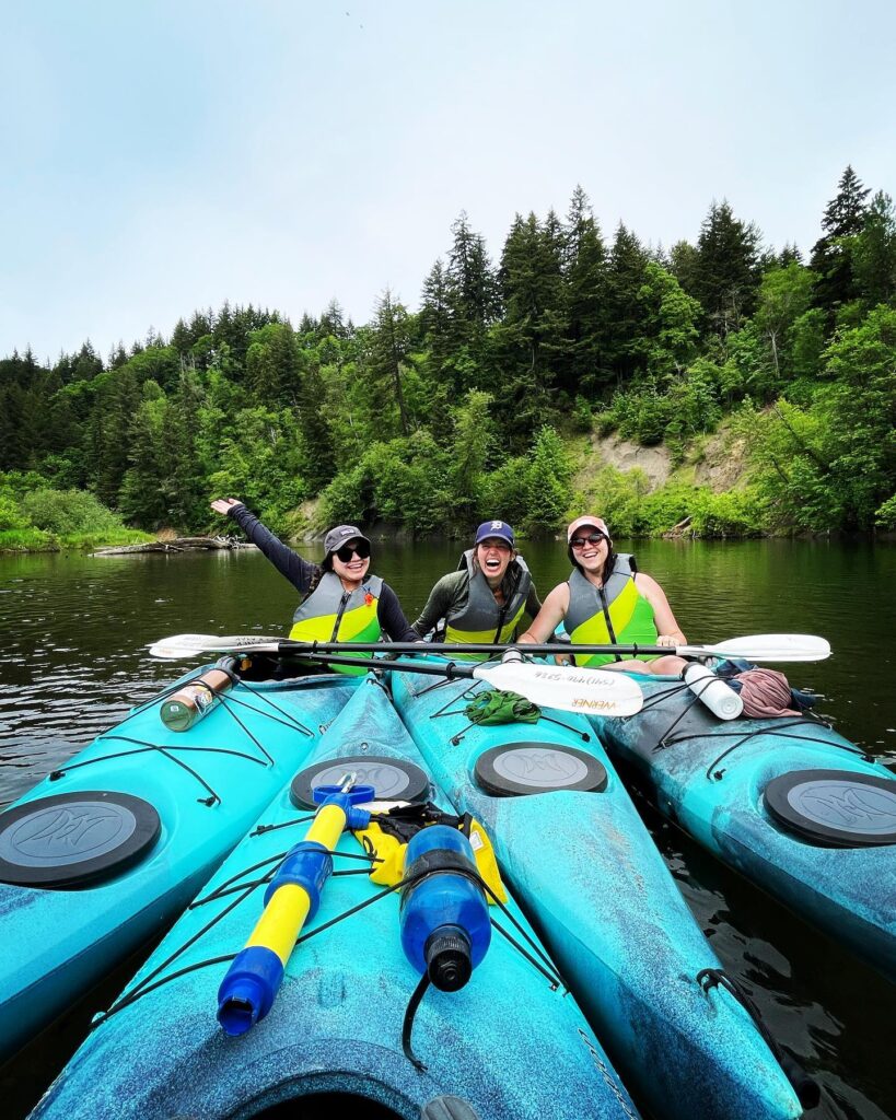 A group of kayakers on the water pose together.