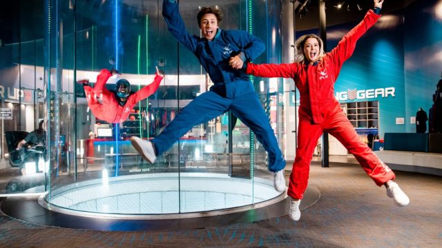 A couple jumping and about to go into the iFLY tunnel.