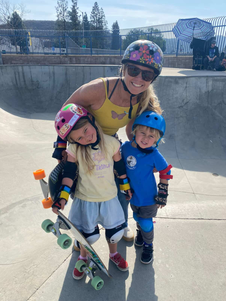 A Mom and her kids a the skatepark.