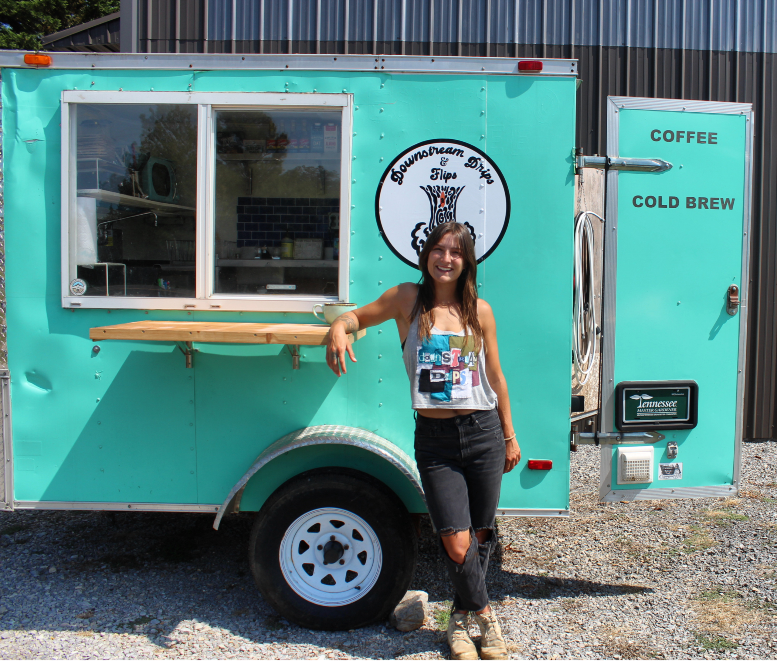 A girl standing in front of a blue food truck.