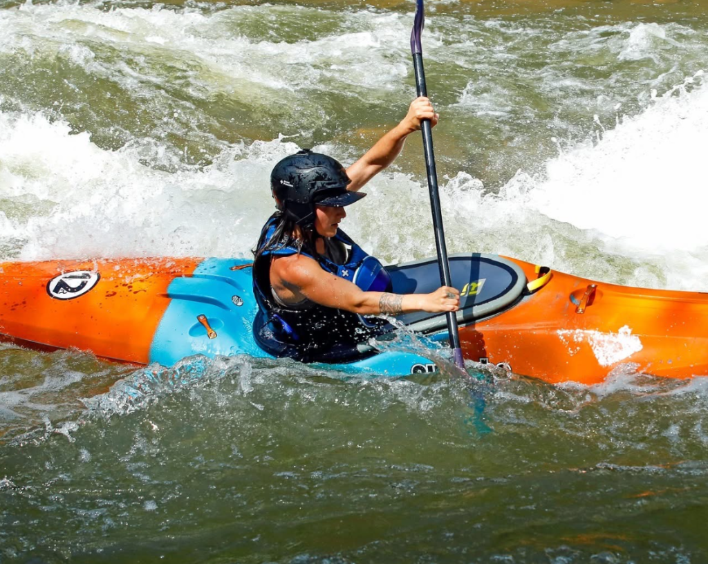 A girl kayaking in a long boat.