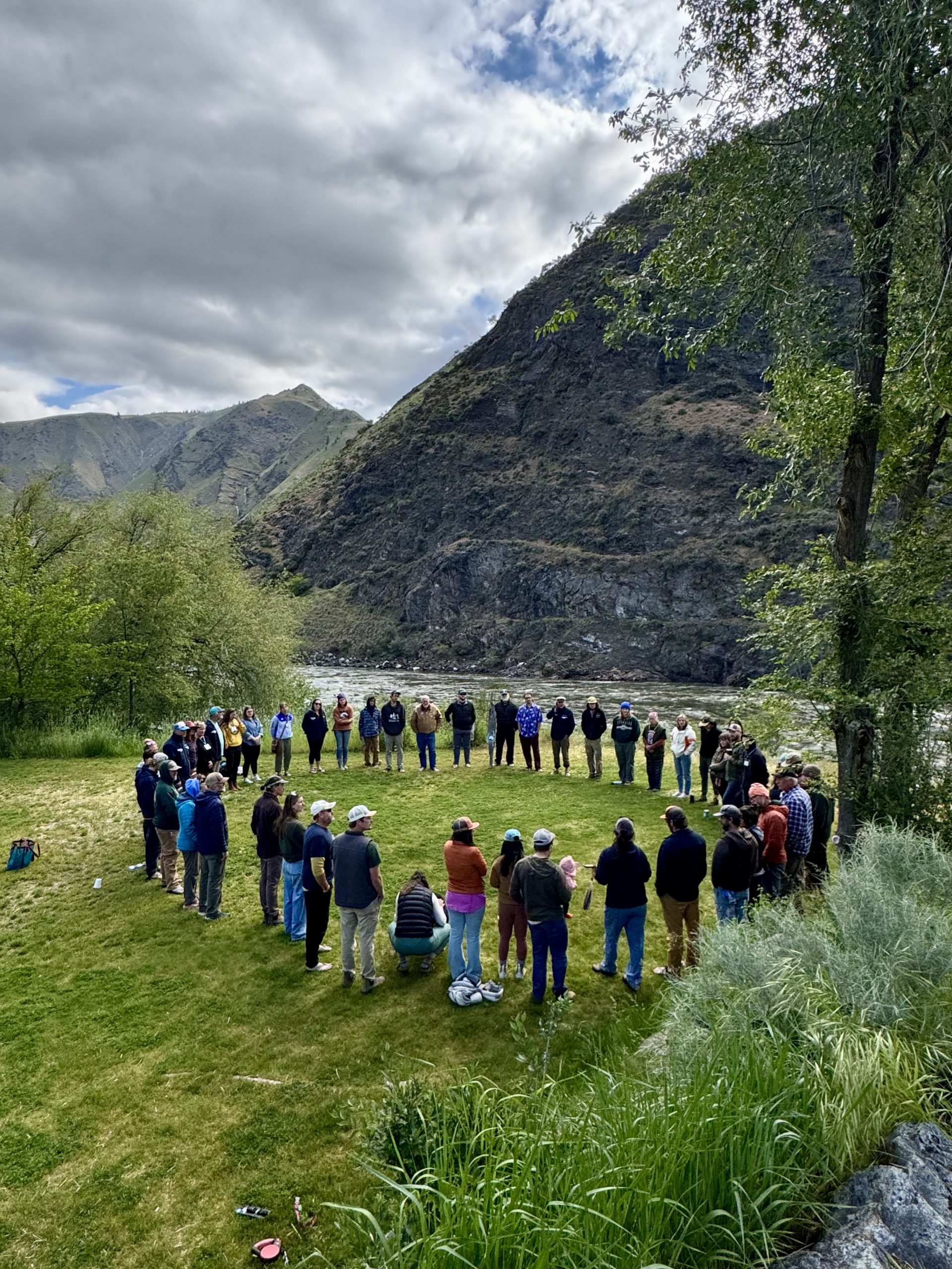 A group of Guides standing together in a circle in a green field.