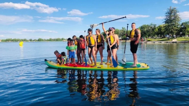 a group of people sharing one paddleboard.
