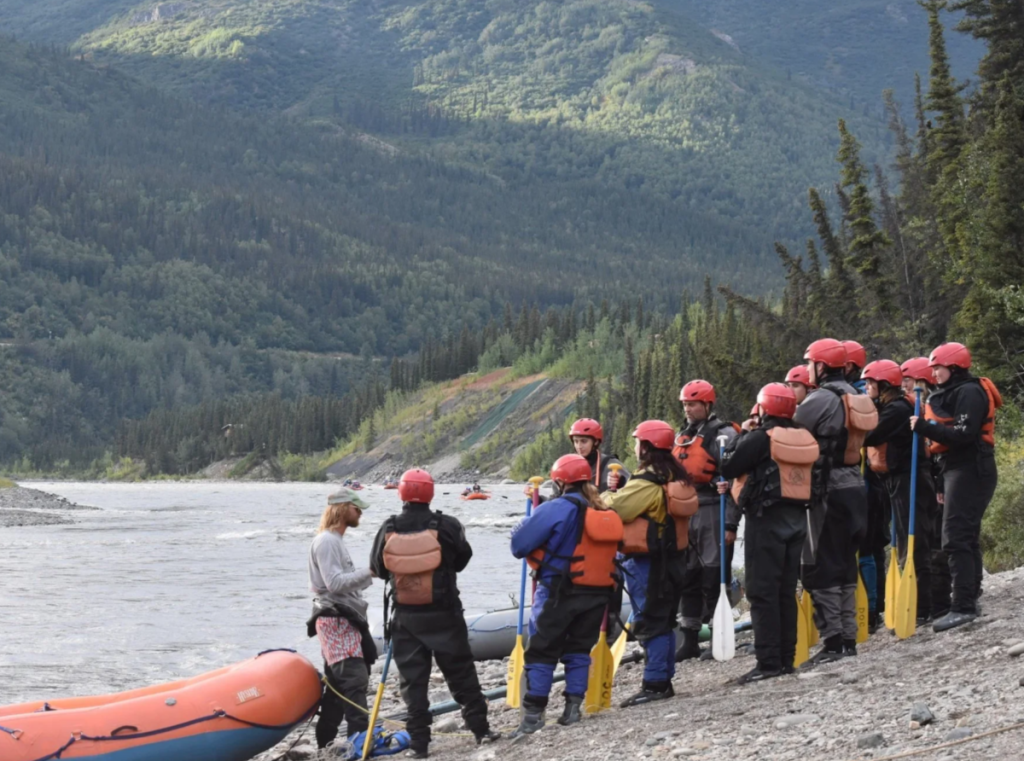 A group of rafters on the shore of an Alaskan river.