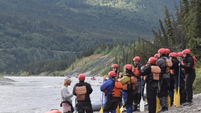 A group of rafters on the shore of an Alaskan river.