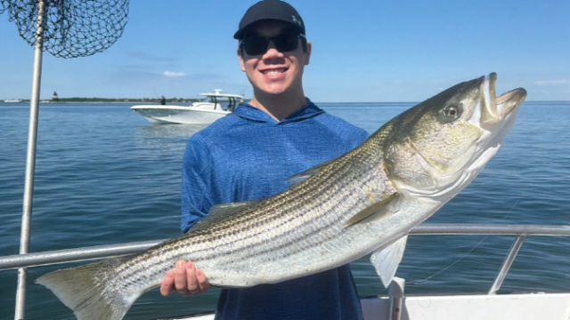 A man holding a fish on a boat.
