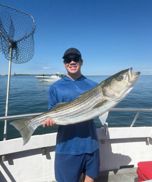 A man holding a fish on a boat.