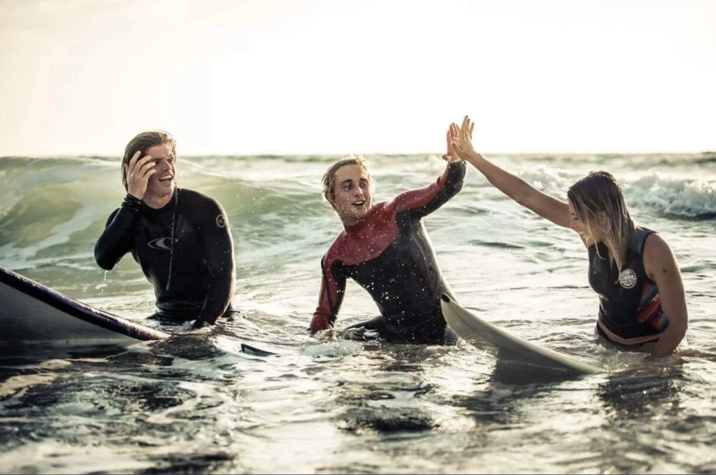 Three surfers in the ocean New York.