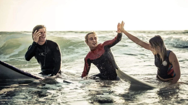 Three surfers in the ocean New York.