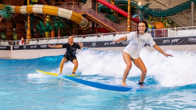 Two surfers on an indoor surf wave in New Jersey.